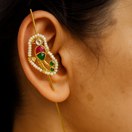 Close-up of an ear with a decorative gold and gemstone earring.