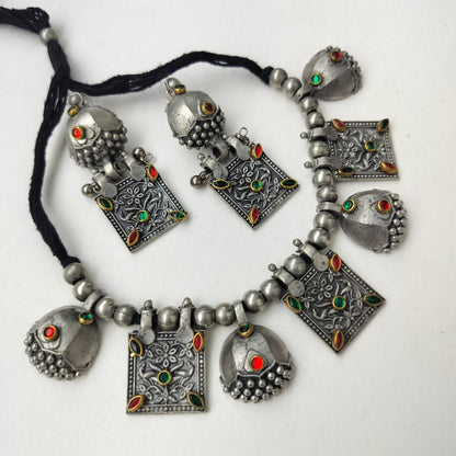 Silver necklace with decorative pendants on a white background