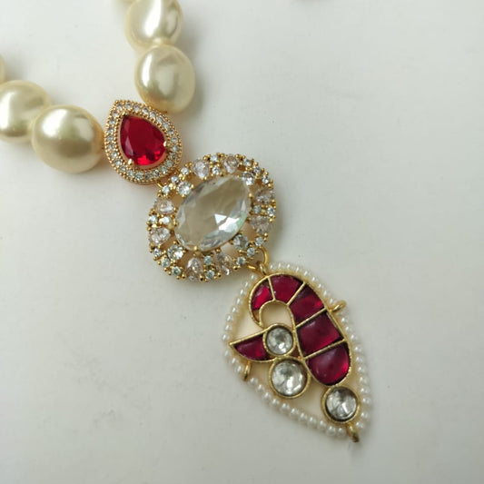 Pearl necklace with red and gold jewelry on a white background