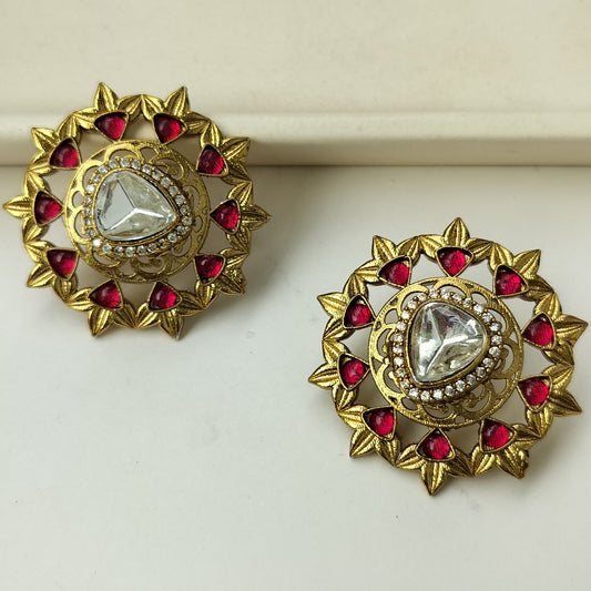 Pair of gold earrings with red gemstones on a white background